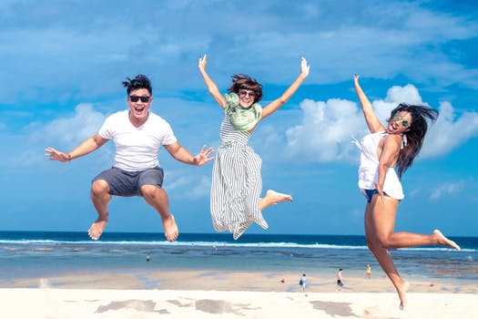 people jumping for joy on the beach